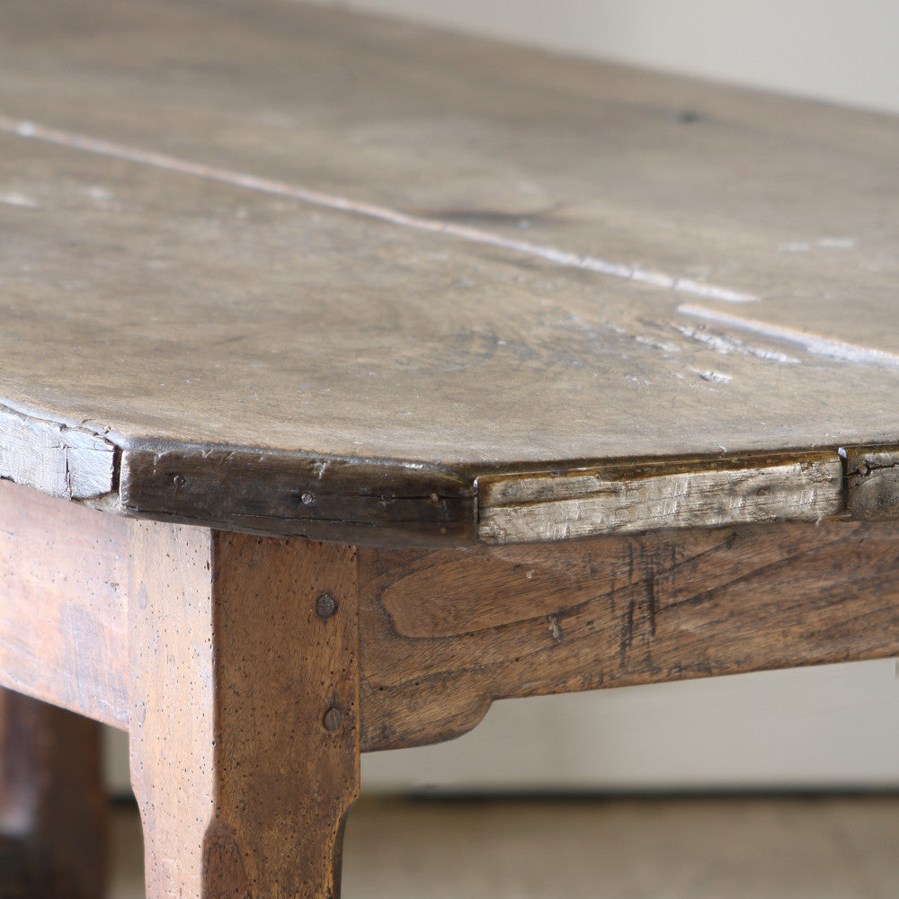 A clear close up of the leg and end of table top of Walnut French farmhouse table